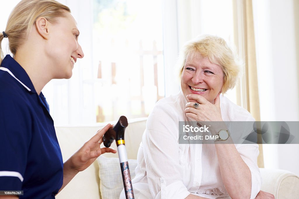 Starszy kobieta szczęśliwa pielęgniarka rozmowy z - Zbiór zdjęć royalty-free (60-64 lata)
