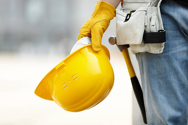 under construction builder with yellow helmet and working gloves on building site arm hammer stock pictures, royalty-free photos & images