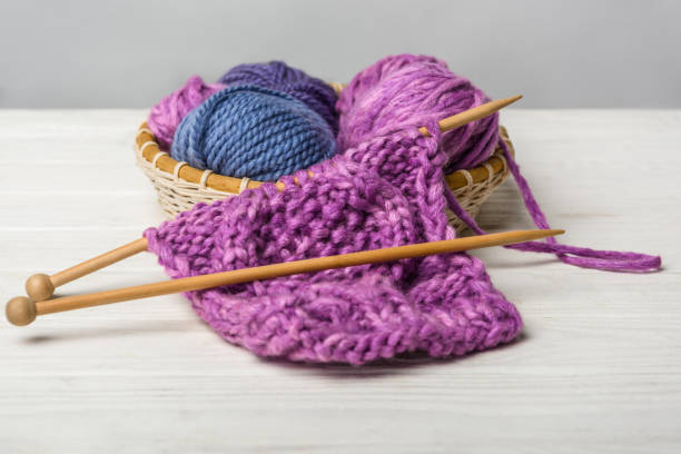 istock close up view of knitting in wicker basket on white tabletop on grey backdrop 1086969404