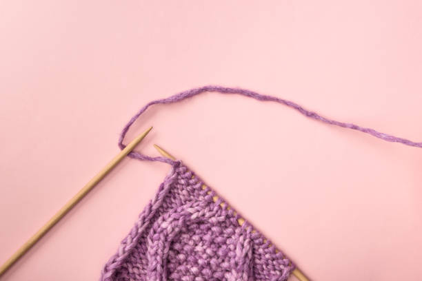 istock flat lay with purple yarn and knitting needles on pink surface 1086969542