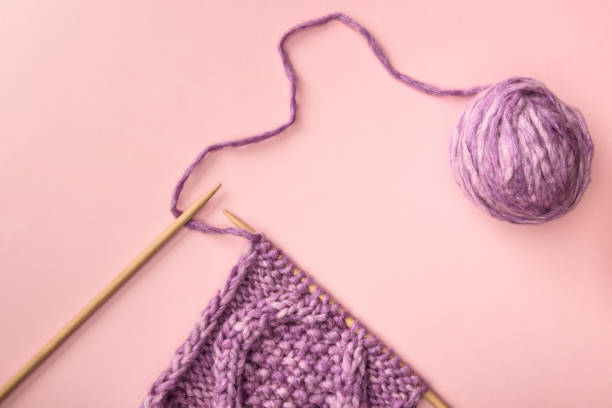 istock flat lay with purple yarn and knitting needles on pink surface 1086969544