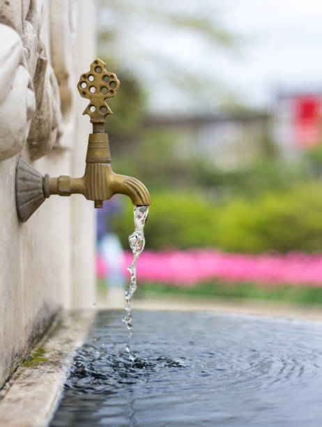 istock Water pouring from a tap in an old fountain 1086977074