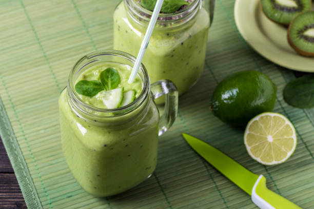 istock Green smoothie on green background made by avocado, lemon and kiwi. 1086977410