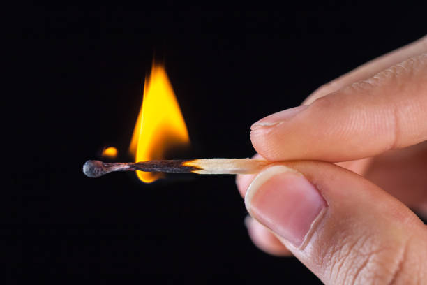 istock burning match stick in the hand on a black isolated background 1086988274