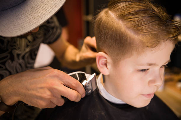 Closeup Of Man Hands Grooming Kid Boy Hair In Barber Shop Boy Cut With  Hairdressers Machine Portrait Of Male Child At The Barber Shop To Cut His  Hair Stock Photo - Download
