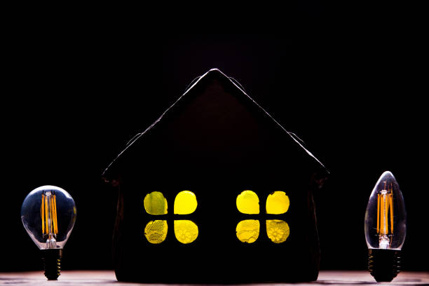 silhouette led lampes dans le contexte de la silhouette de l’agencement de la maison sur un fond noir. - piggy bank savings investment glasses photos et images de collection