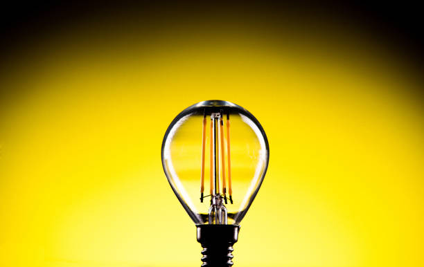 silhouette lampe led fond jaune. - piggy bank savings investment glasses photos et images de collection