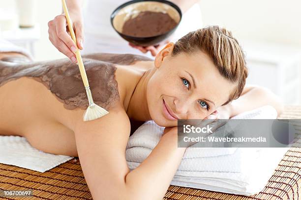 Foto de Bela Jovem Mulher Desfrutar De Um Tratamento De Beleza Com Lama e mais fotos de stock de Costas