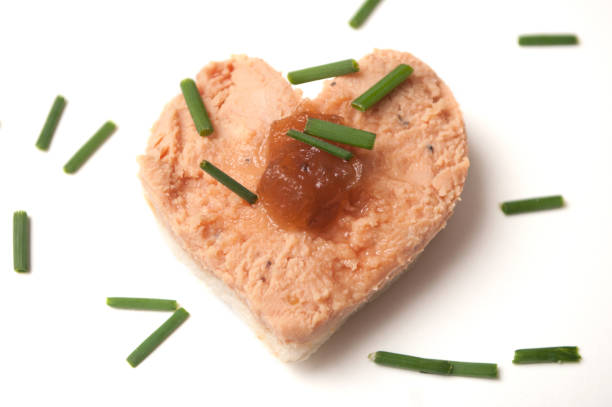 closeup of foie gras on bread in shaped heart onwhite background