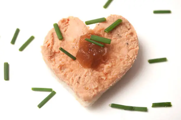 Photo of foie gras on bread in shaped heart onwhite background