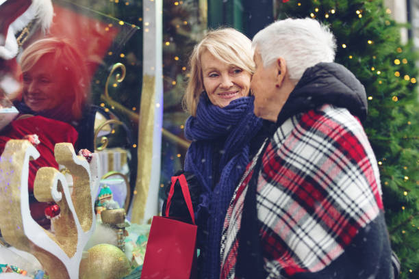 donna anziana con la figlia che fa shopping per natale - senior adult winter senior women daughter foto e immagini stock