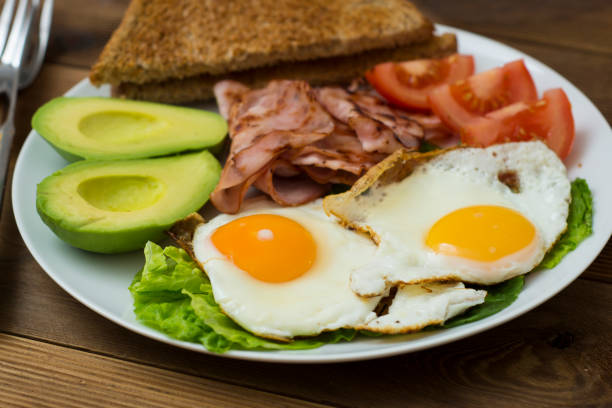 istock Healthy breakfast. Avocado, eggs sandwich with whole grain bread on wooden background. Copy space 1087017784
