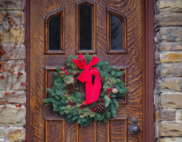 istock front door with Christmas wreath made of pine branches 1087017846