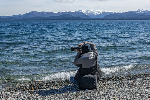 Photographer registering outdoor landscapes in cold season in Bariloche, Patagonia Argentina