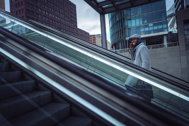istock Businessman using smart phone on the escalator 1087026210