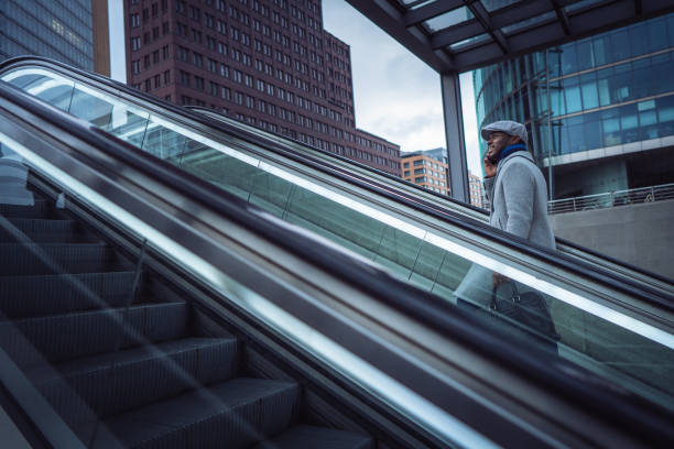 istock Businessman using smart phone on the escalator 1087026260