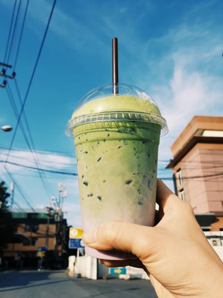 istock Hand holding a plastic cup of iced green tea 1087030262