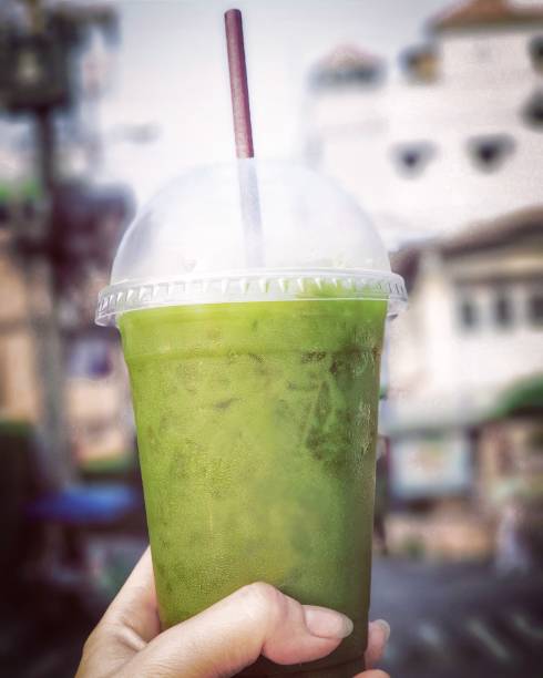 istock Hand holding a plastic cup of iced green tea 1087030278