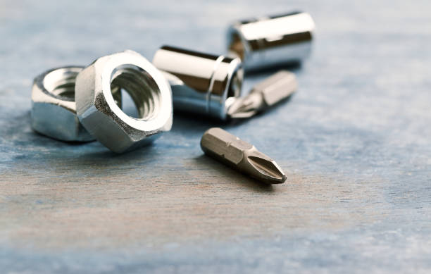 istock Bits for a screwdriver and hex nuts on wooden background. Close up. Copy space. 1087030472