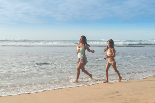 istock Mom running with her daughter along the beach 1087032350