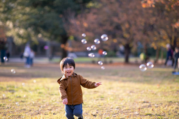 istock Little boy playing with soap bubbles in public park 1087054244