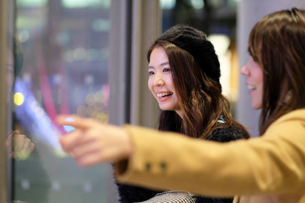 istock Women looking at display window on night street 1087070296