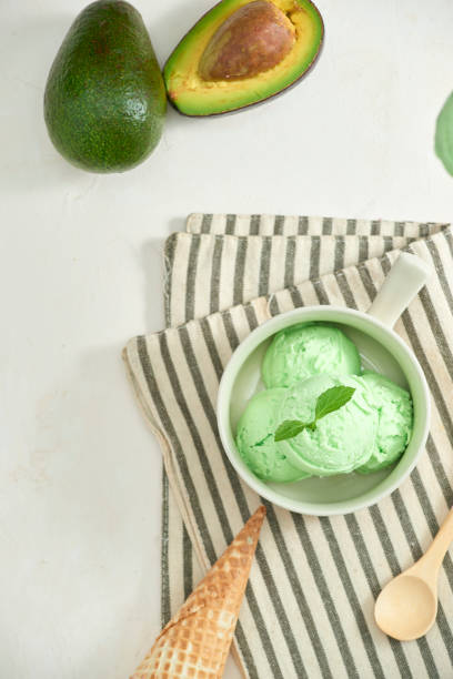 istock homemade organic avocado ice cream, with ice cream cones. On a grey stone table, copy space 1087084442