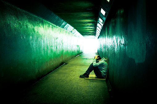 Homeless Depressed Man Sitting in Cold Subway Tunnel