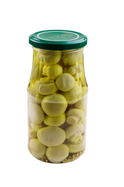 istock Delicious marinated mushrooms in glass jar isolated on white background 1087097498