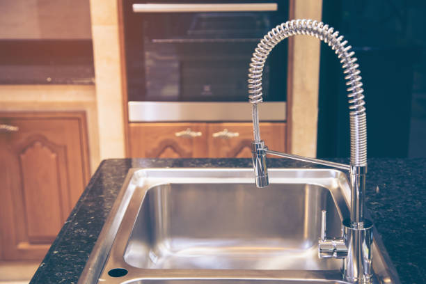 istock Designed kitchen with glossy countertop and stainless steel faucet 1087104238
