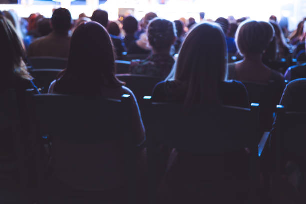 People in the theater auditorium during the performance. Soft focus People in the theater auditorium during the performance. Soft focus. hair band stock pictures, royalty-free photos & images