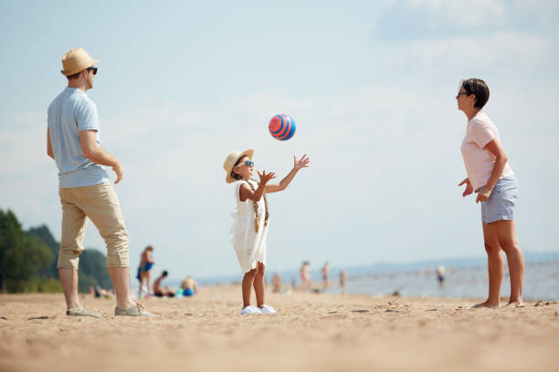 istock Family Playing Ball by Sea 1087110908