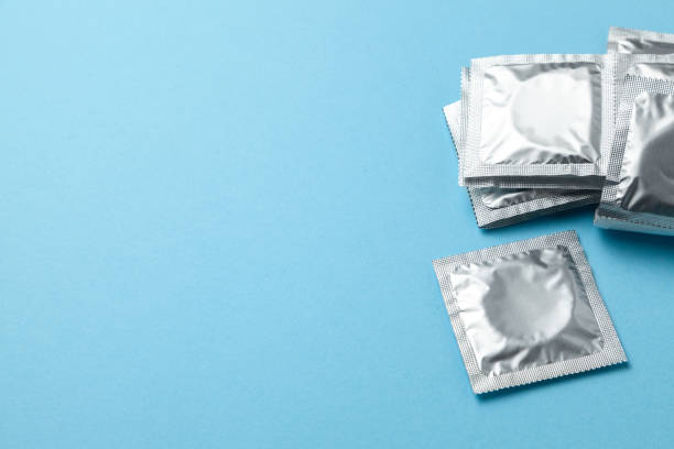 Condoms in pack on blue background. Copy space for text. Condoms in pack on blue background. Copy space for text condom photos stock pictures, royalty-free photos & images