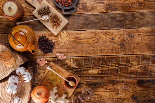 Autumn winter still life. Teapot with tea on a wooden table with honey ginger and rosehip. The apartment lay. The space under the text. stock photo