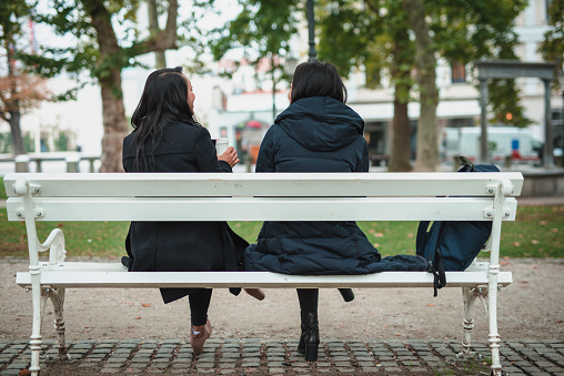 Friends sitting on a bench and talking