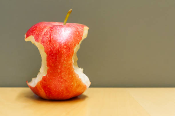 czerwone ugryzione jabłko w stole - apple biting missing bite red zdjęcia i obrazy z banku zdjęć
