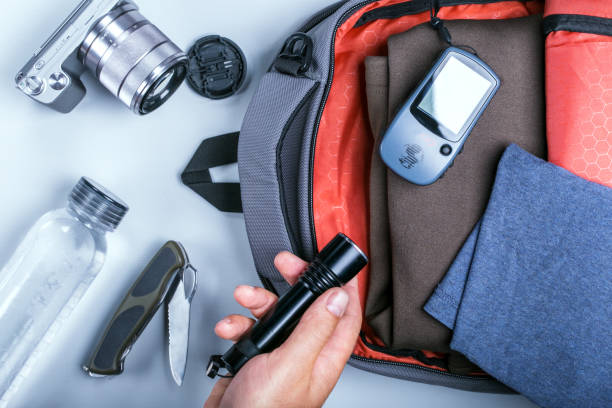 istock packing clothes in the backpack for travel with accessories concept. 1087133120