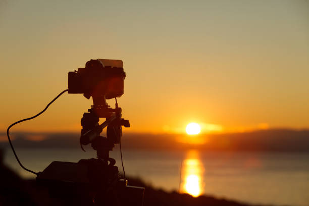istock Camera taking picture of sunrise over sea surface 1087140202