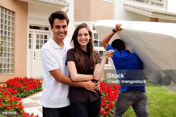 Couple With Mover Carrying A Mattress Stock Photo - Download Image Now - Mattress, Furniture, Delivering