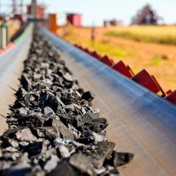 Close up of Manganese rock on a conveyor belt Close up of Manganese rock being moved on a conveyor belt mining conveyor belt stock pictures, royalty-free photos & images