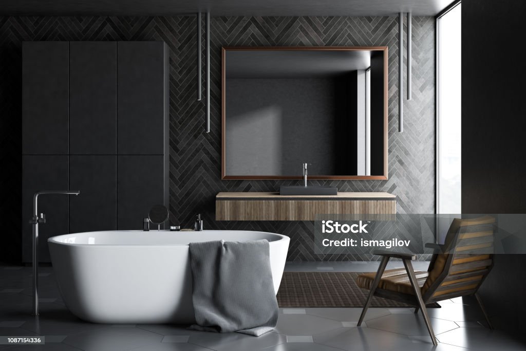 Black wooden bathroom with closet Bathroom interior with black wooden walls, dark tiled floor, white bathtub, black sink on wooden counter, an armchair and black closet in the corner. 3d rendering Appliance Stock Photo