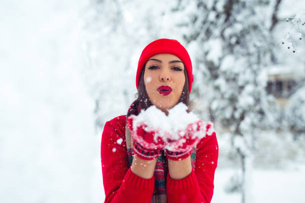 istock Young woman blowing snow from her hands 1087157818