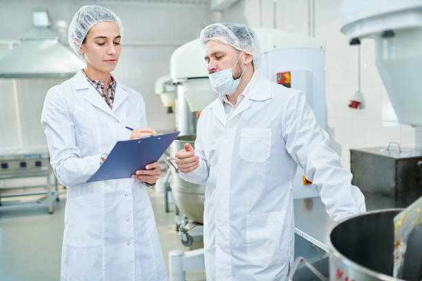 istock Professional confectioners discussing in factory 1087171468