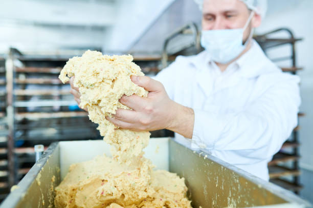 Confectionery factory worker holding dough in hands