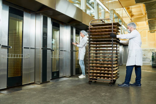 istock Confectionery factory workers transporting trays rack 1087171524
