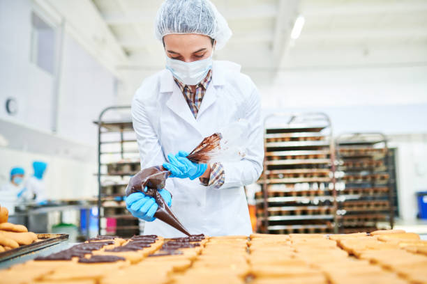 istock Confectioner squeezing chocolate cream from pastry bag 1087171550