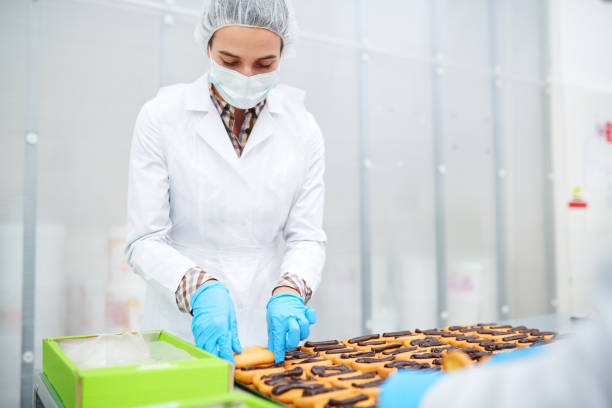 istock Confectionery factory worker packing ready pastry 1087171556