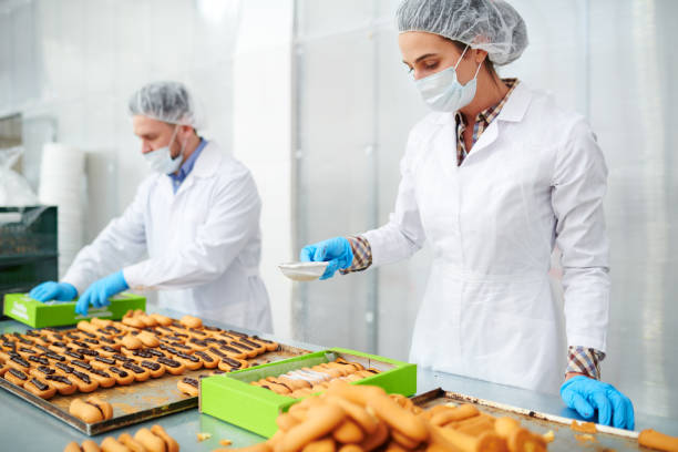 istock Confectionery factory employee dusting pastry with powdered sugar 1087171562