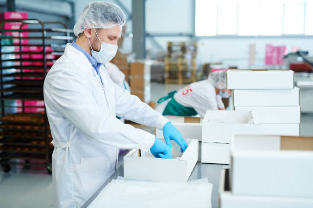 istock Confectionery factory employee preparing empty box 1087171584