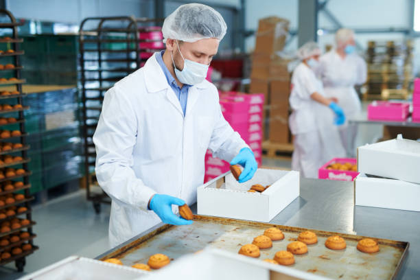 istock Confectionery factory worker packing pastry into box 1087171602